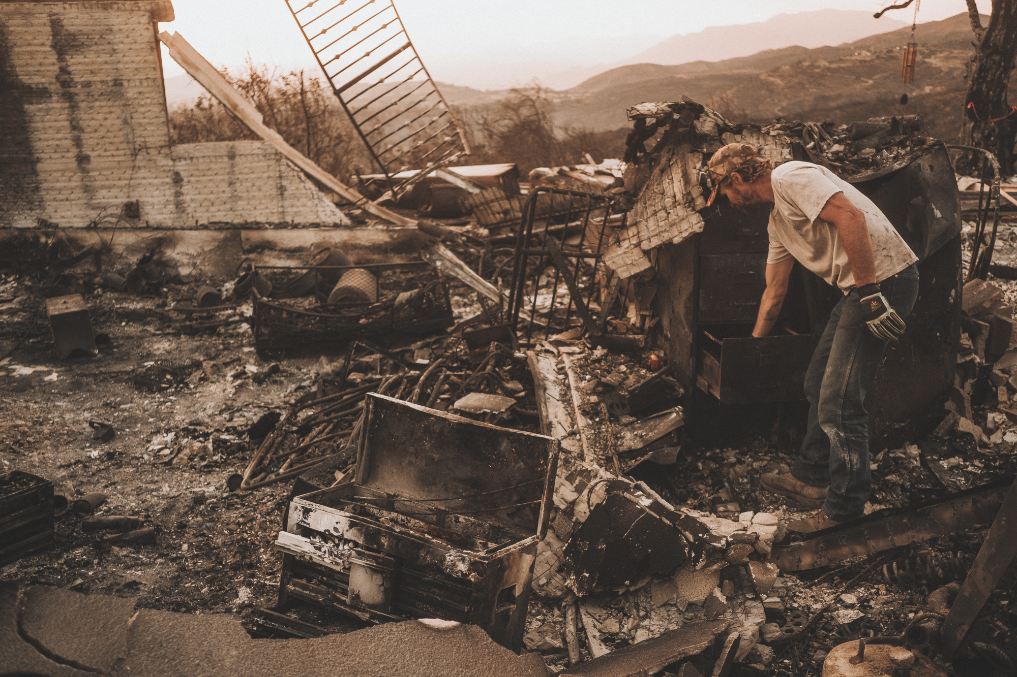 A Ventura County man picks through the remains of a home shortly after it was destroyed by the Thomas Fire. Photo: Dylan Gordon
