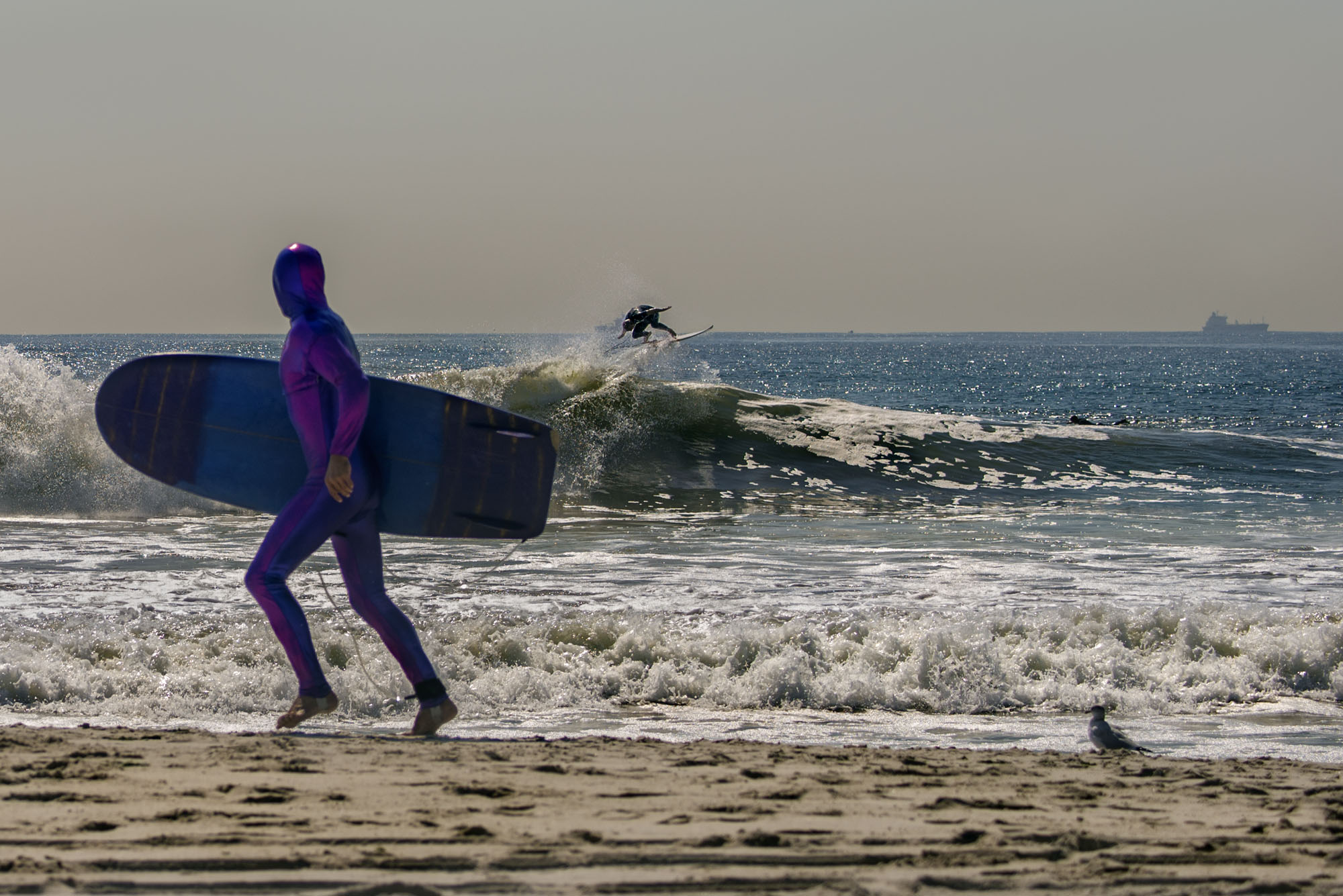 New Yorkers have been known for decades as a pane unto themselves. The photo of the purple-wetsuited surfer jogging by as another tries an ‘air’ in the background tweaks the norm of black wetsuits and uncrowded surf usually seen in magazines. Vividly abnormal, it murmurs strange breed these parts.” Derek Hynd (from Surf NYC), September 18, 2014
Lido Beach, NY, Surfer: Thaddeus O’Neil 