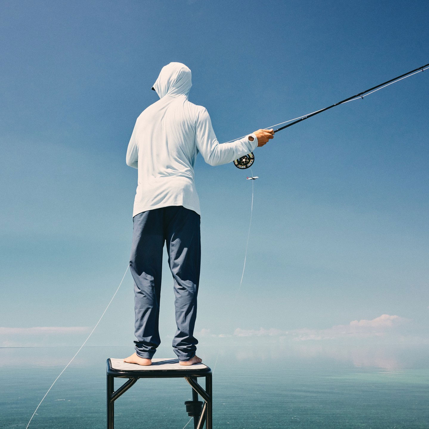 FreeFly Apparel image - person standing on fishing boat platform casting rod