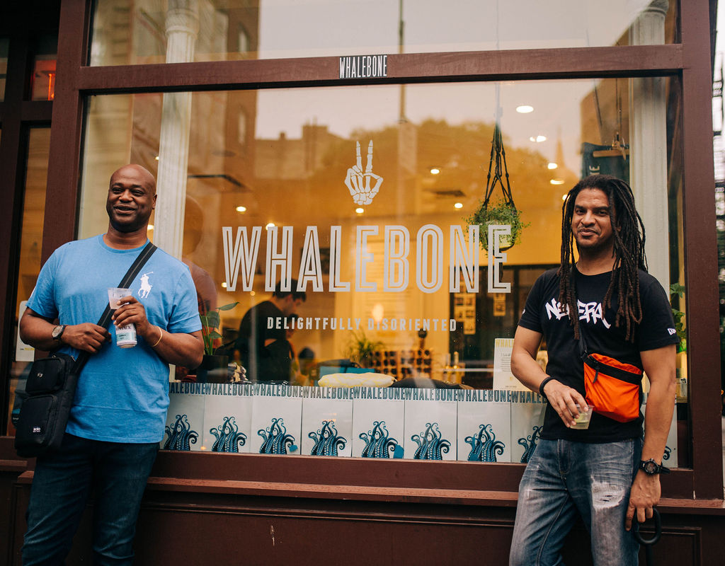 Two men with messengers bag standing outside the window of the whalebone store on bleecker