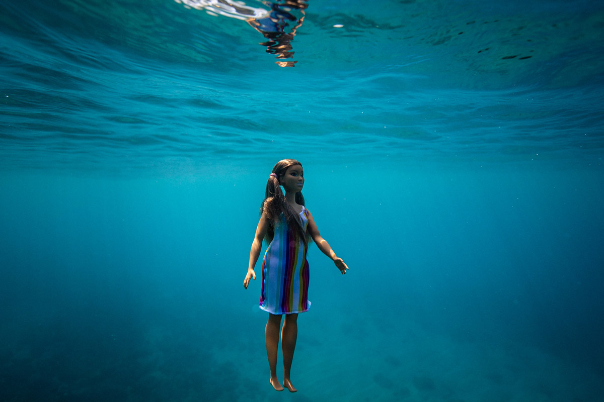 Image of a brown barbie doll underneath the water.
