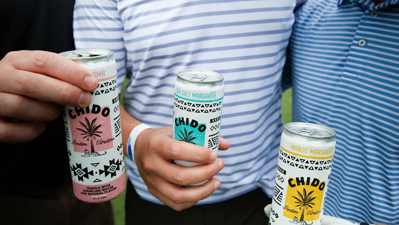Three cans of chido being held by three people