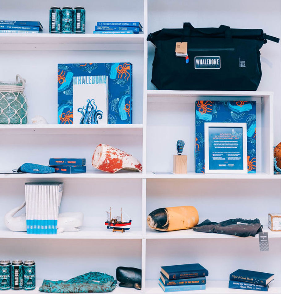 Shelves in the store with GOT Bag, magazine, Shinola watch box, books and montauk brew co