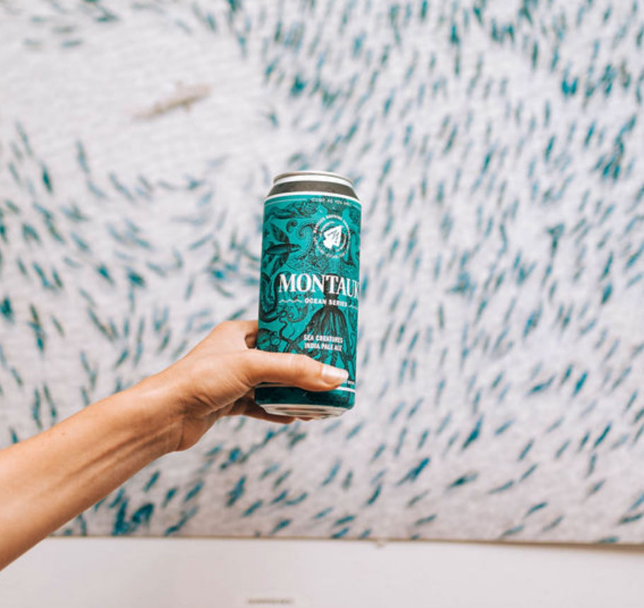 a hand holding up a can of montauk brew co sea creatures india pale ale