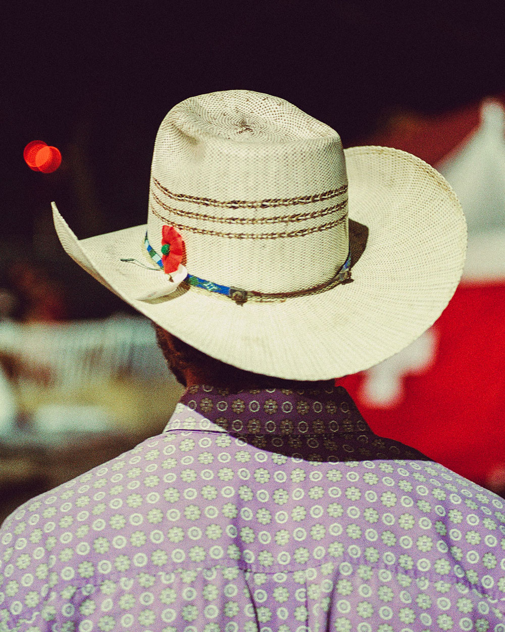 A back shot of a man wearing a collared shirt and wearing a large white cowboy hat In photograph of Folsom Rodeo 60th Anniversary by Cameron Munn