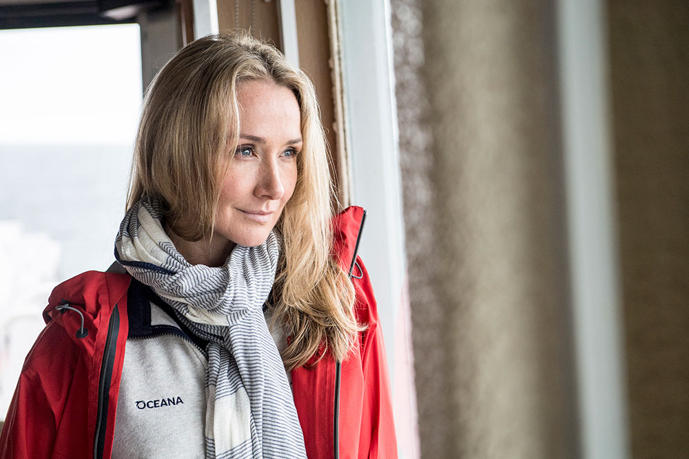 Alexandra Cousteau wearing a jacket and scarf looks off into the distance