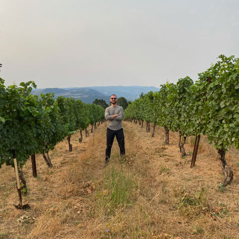 Sean, Sommelier, standing in vineyard