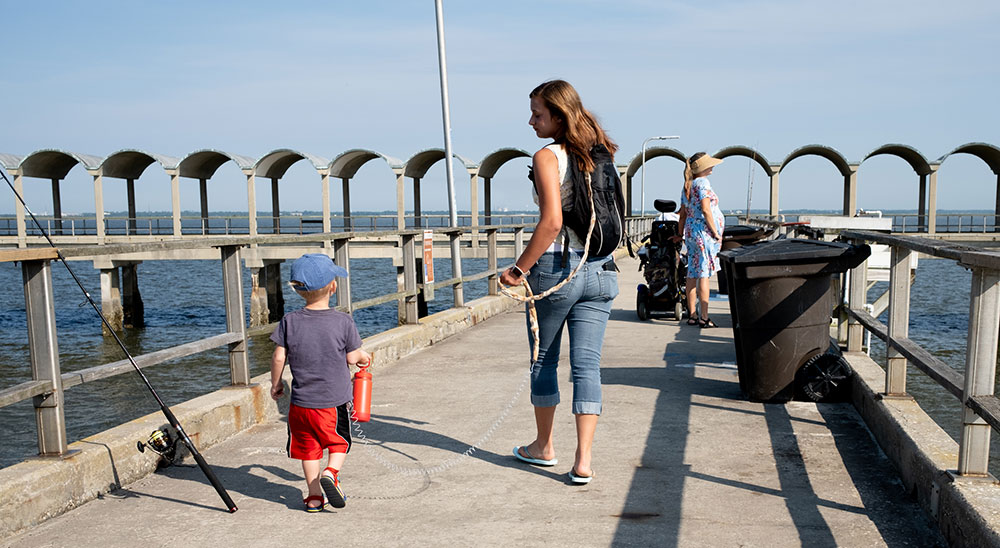 Photo of mother and child walking on public dock taken by Gunner Hughes