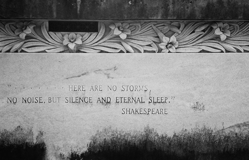 Black and white photo taken by Gunner Hughes of shakespearean quotes engraved into wall