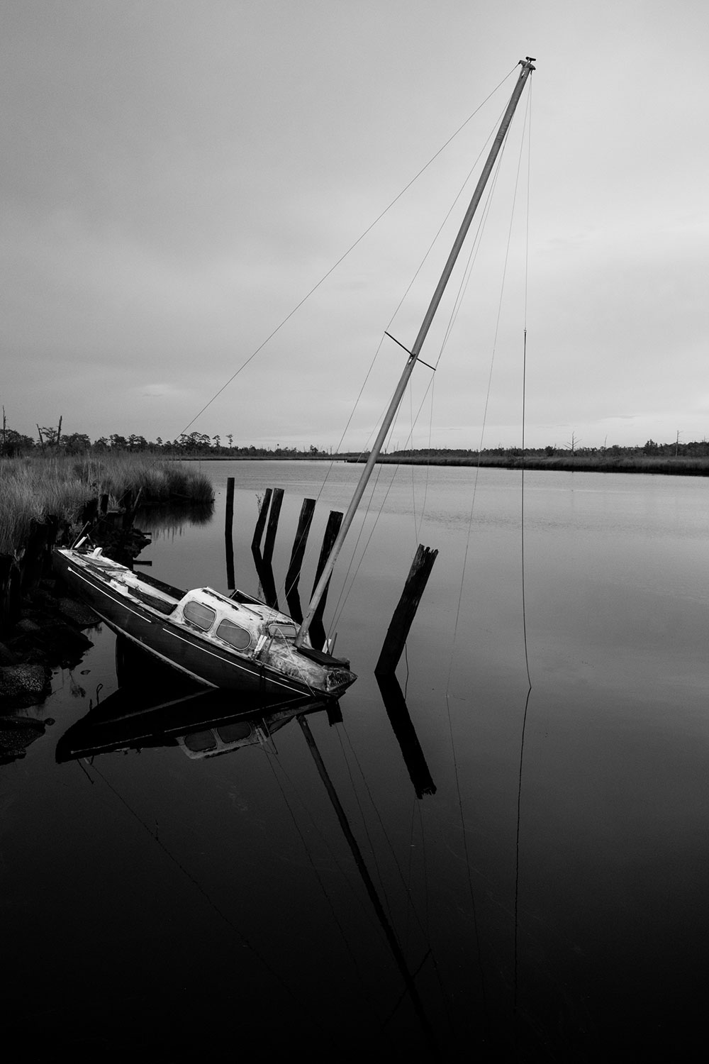 Black and White photo taken by Gunner Hughes of a half sunken sailboat
