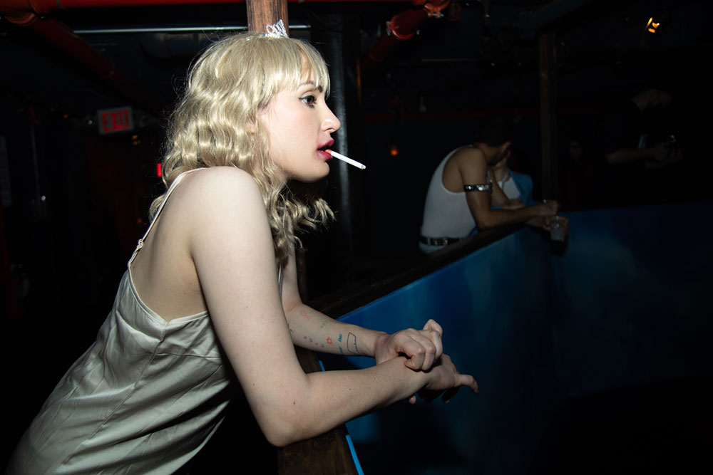 McKittrick Hotel Halloween Party 2021, woman in white slip costume smoking a cigarette