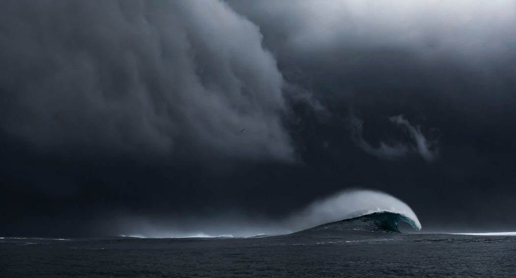 image of stormy sky and ocean with wave crashing taken by Ben Thouard