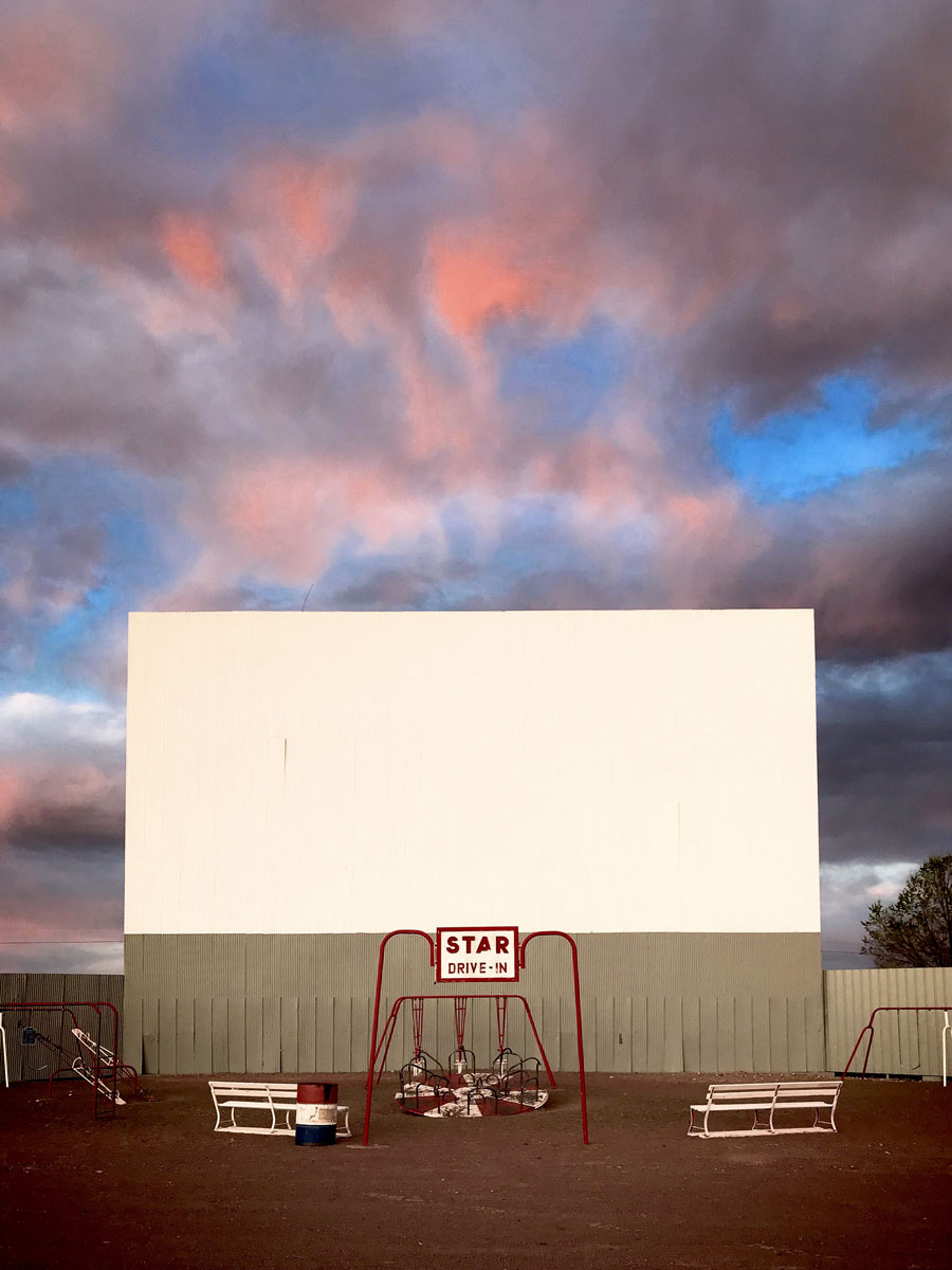 STAR DRIVE-IN THEATRE with sunset sky and big projector screen.