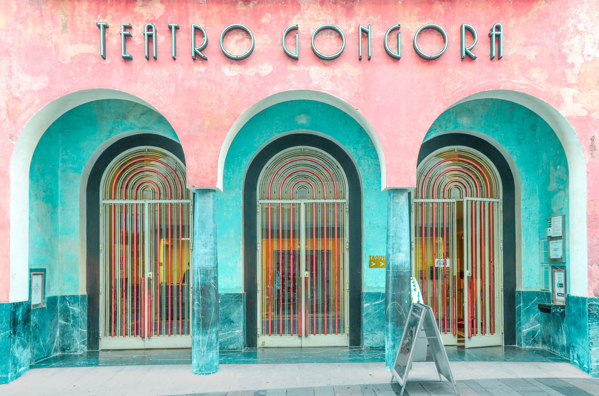 GÓNGORA THEATER exterior shot, pink walls with 3 teal archways.