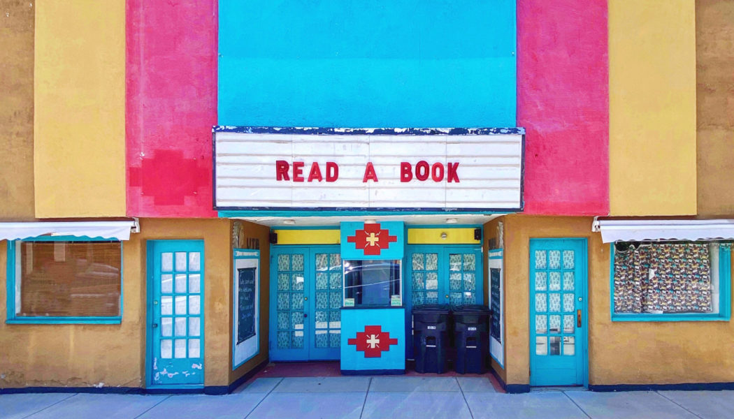 color front of movie theatre with 'Read a book' on the marquee