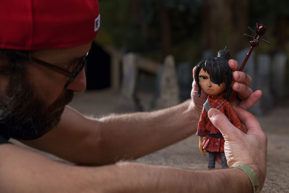 Up close of Brad Schiff adjusting Kubo figurine.