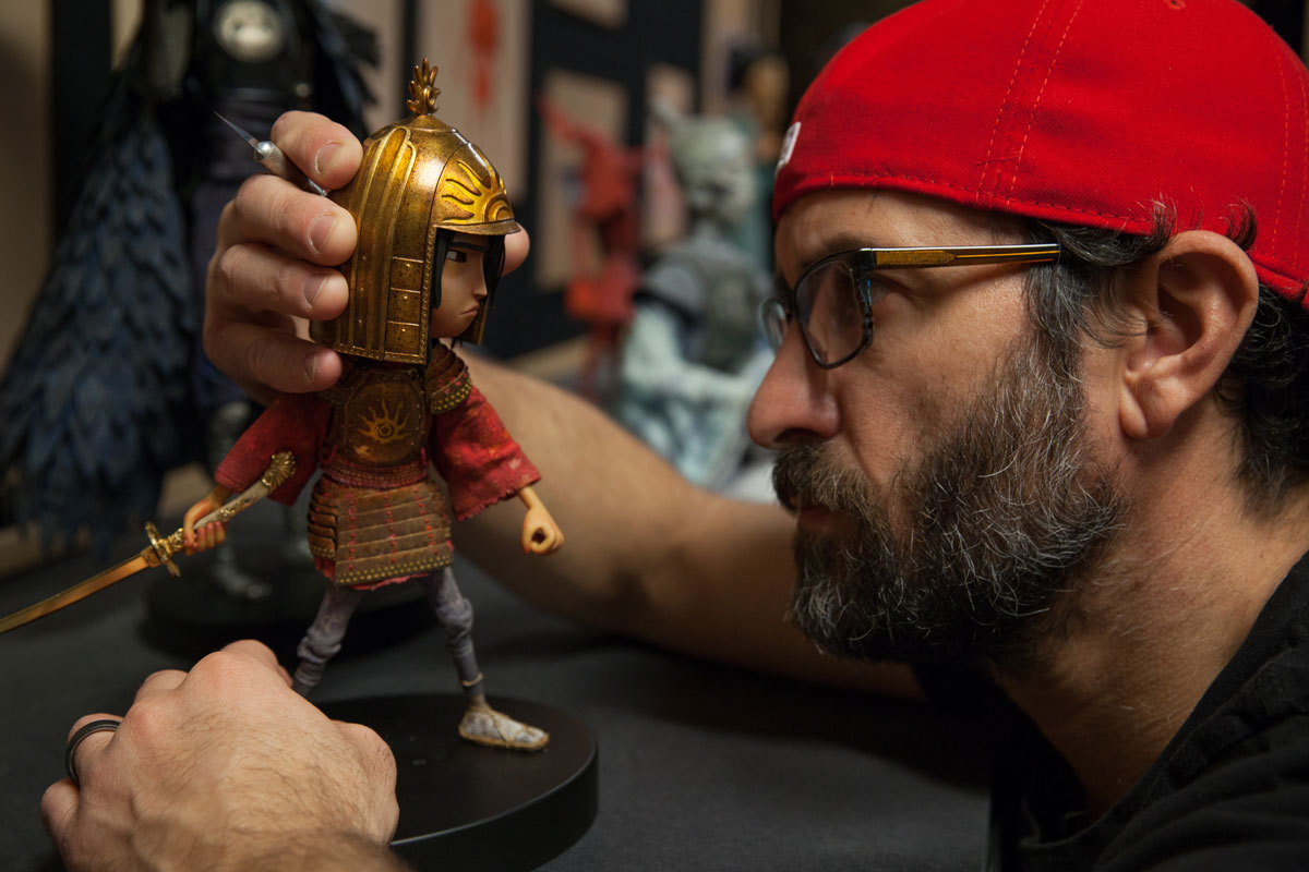 Up close of Brad Schiff inspecting Kubo figurine.