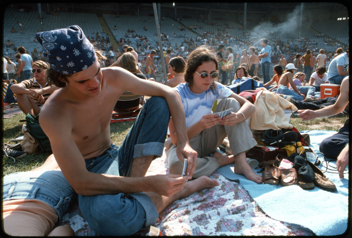 Friends of the photographer play the card game setback in the brilliant sun before the Grateful Dead concert begins.