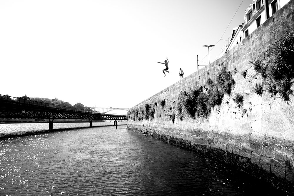 Photo taken by Gunner Hughes of person jumping into water from wall in Europe
