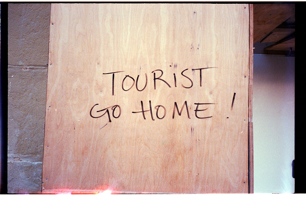 Photo taken by Gunner Hughes of hand written sign in Europe saying "tourist go home"