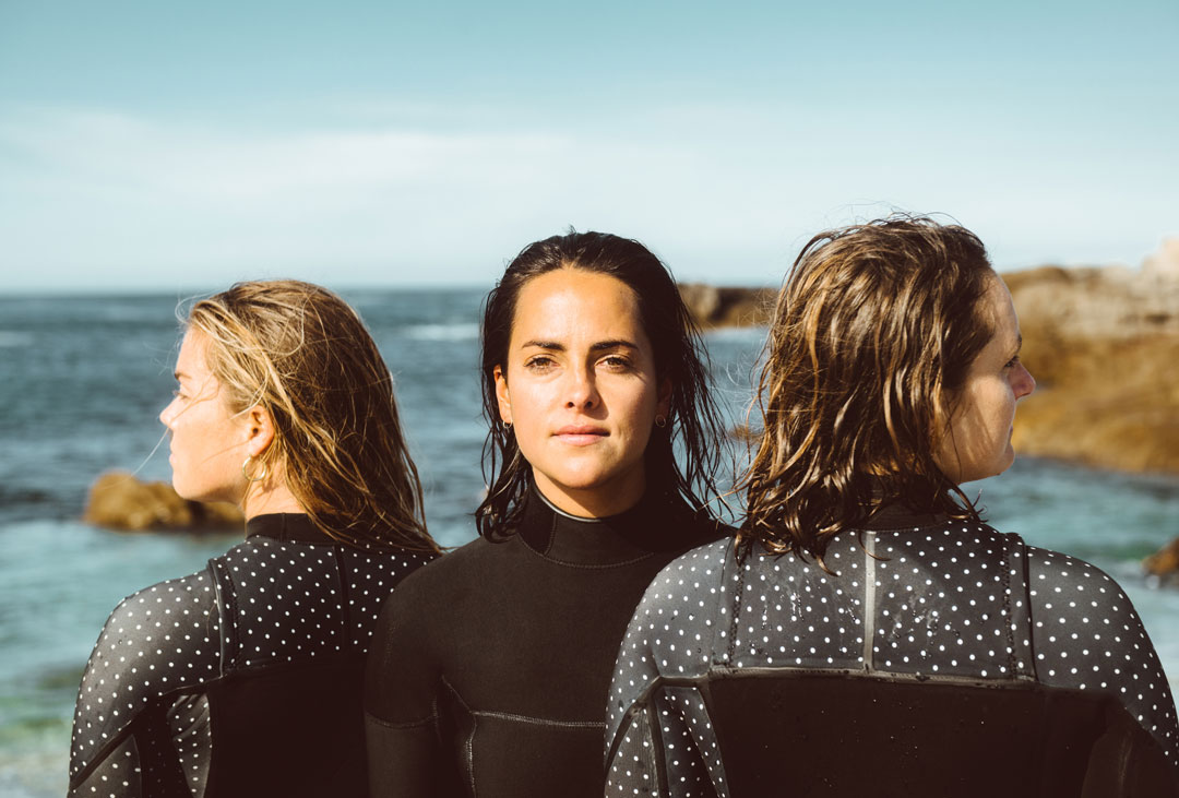 Portrait of three female surfers in wetsuits on the coast of California  by rob schanz