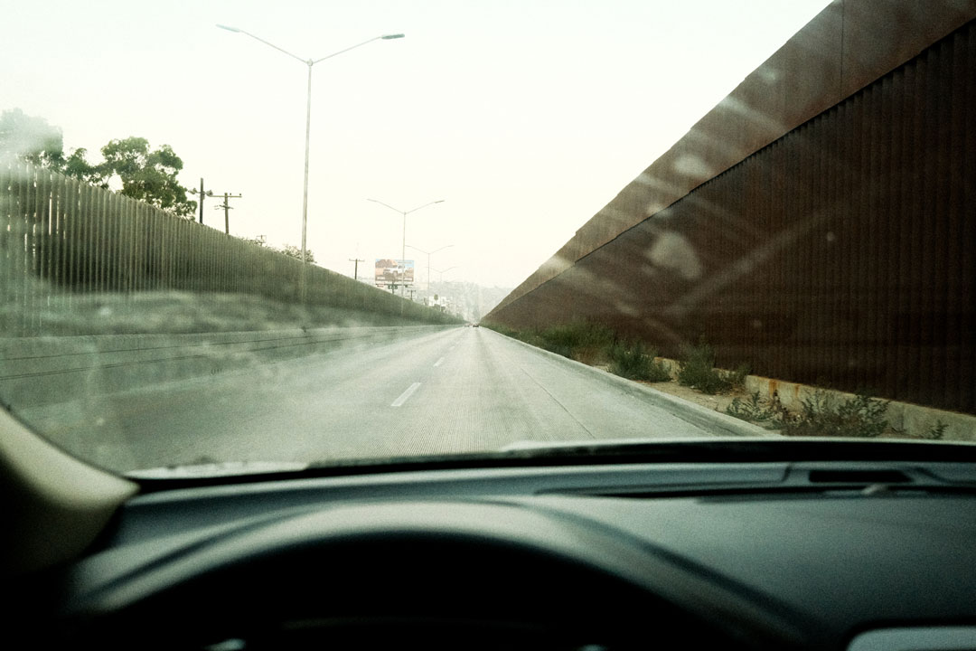 Looking through a dirty car windshield at an empty road. 