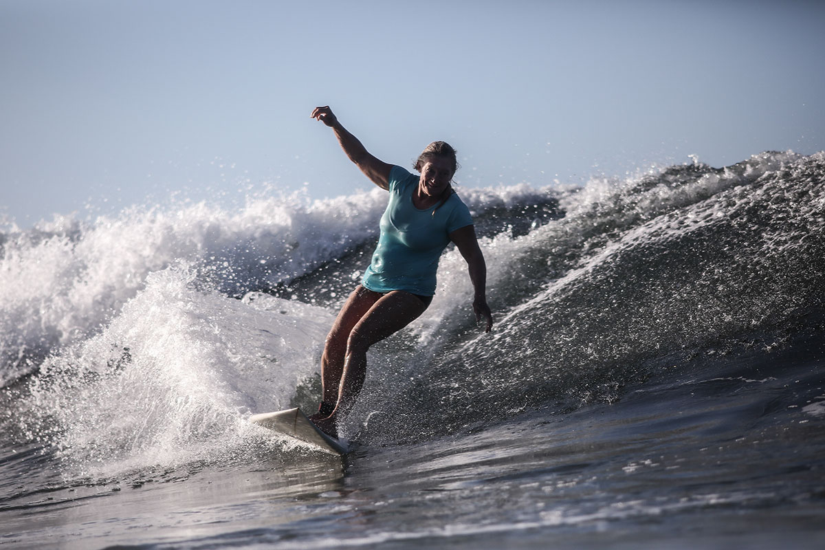 Nature of Surf Women, woman carving wave while surfing