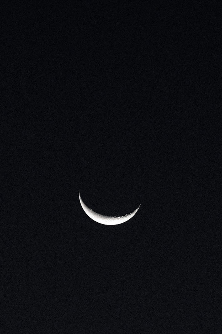 Photo of the crescent moon against the black night sky.