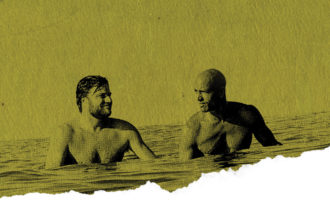 Kelly Slater and Benji Weatherley floating in the ocean surfing, waiting for a wave