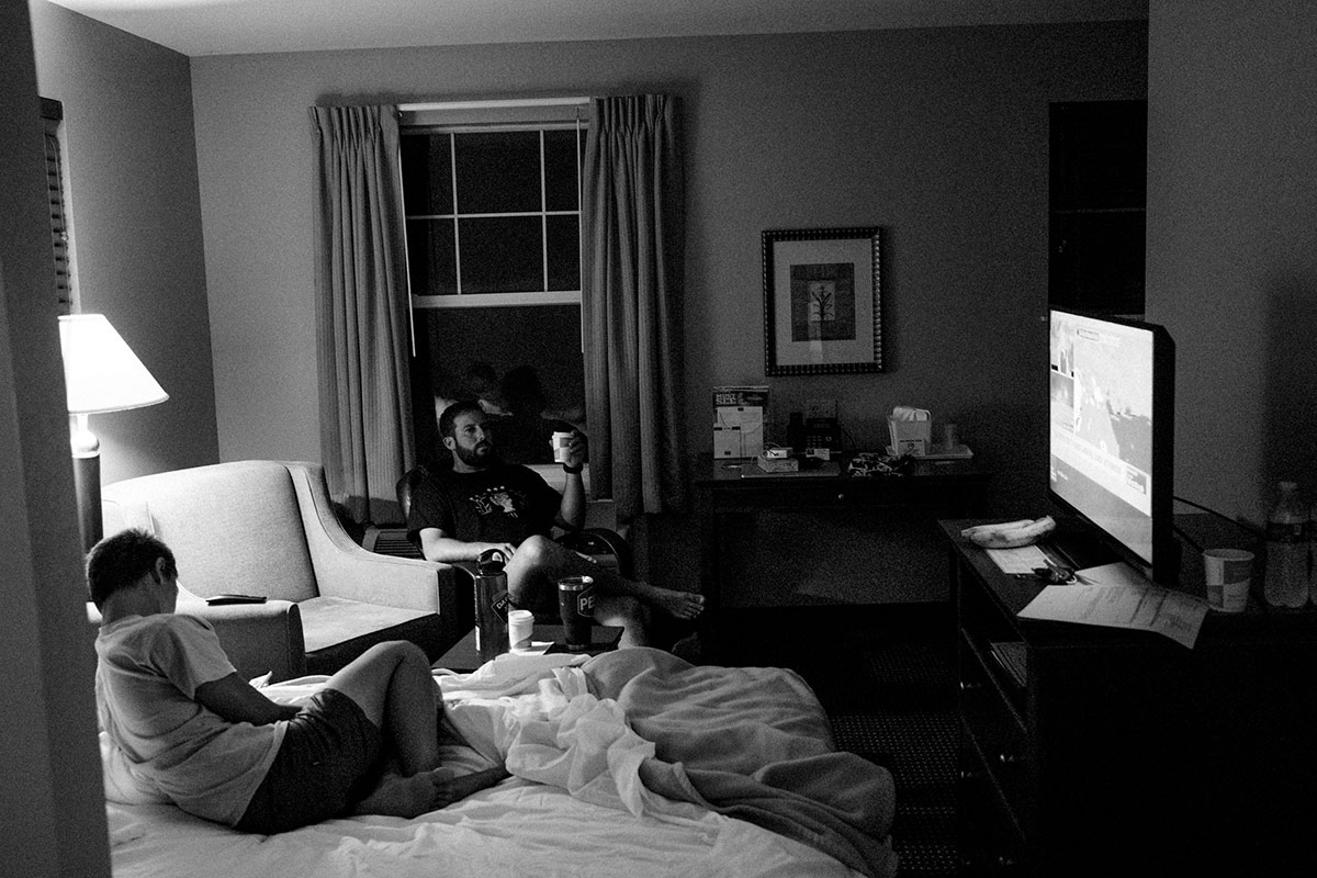 guys hanging in hotel room watching tv
