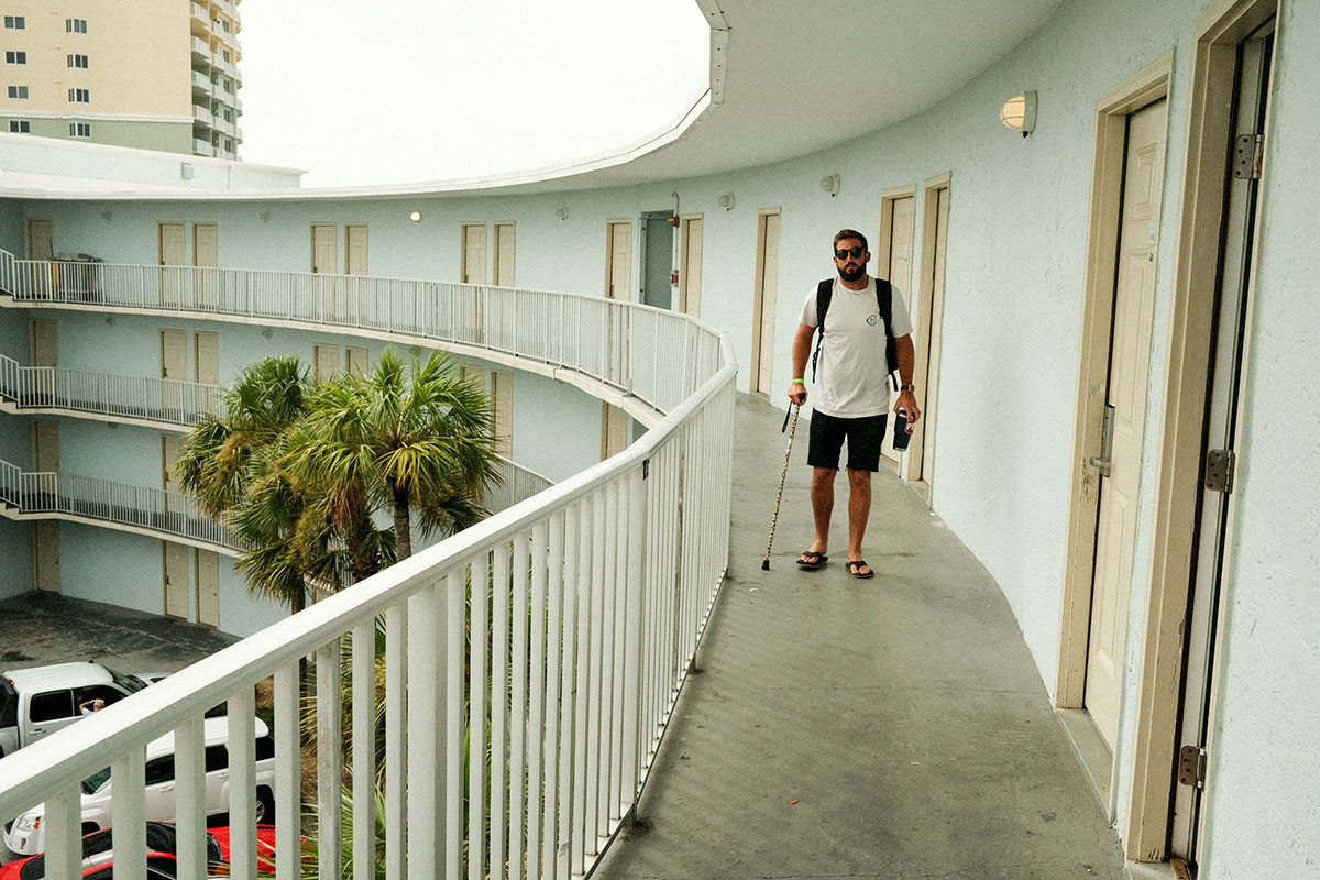 man with can on motel balcony