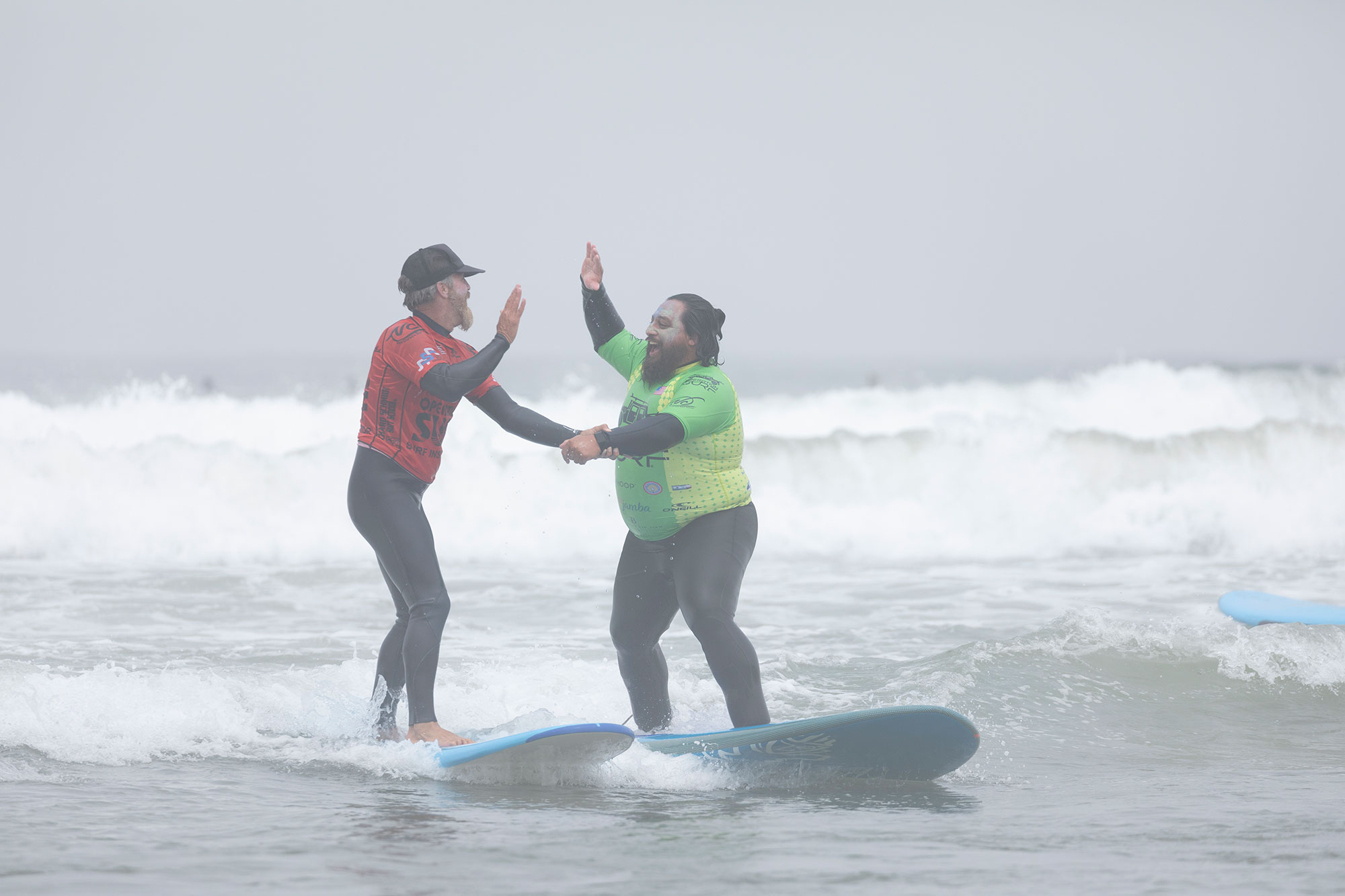 Billy, veteran, highfiving vet support while surfing with operation surf