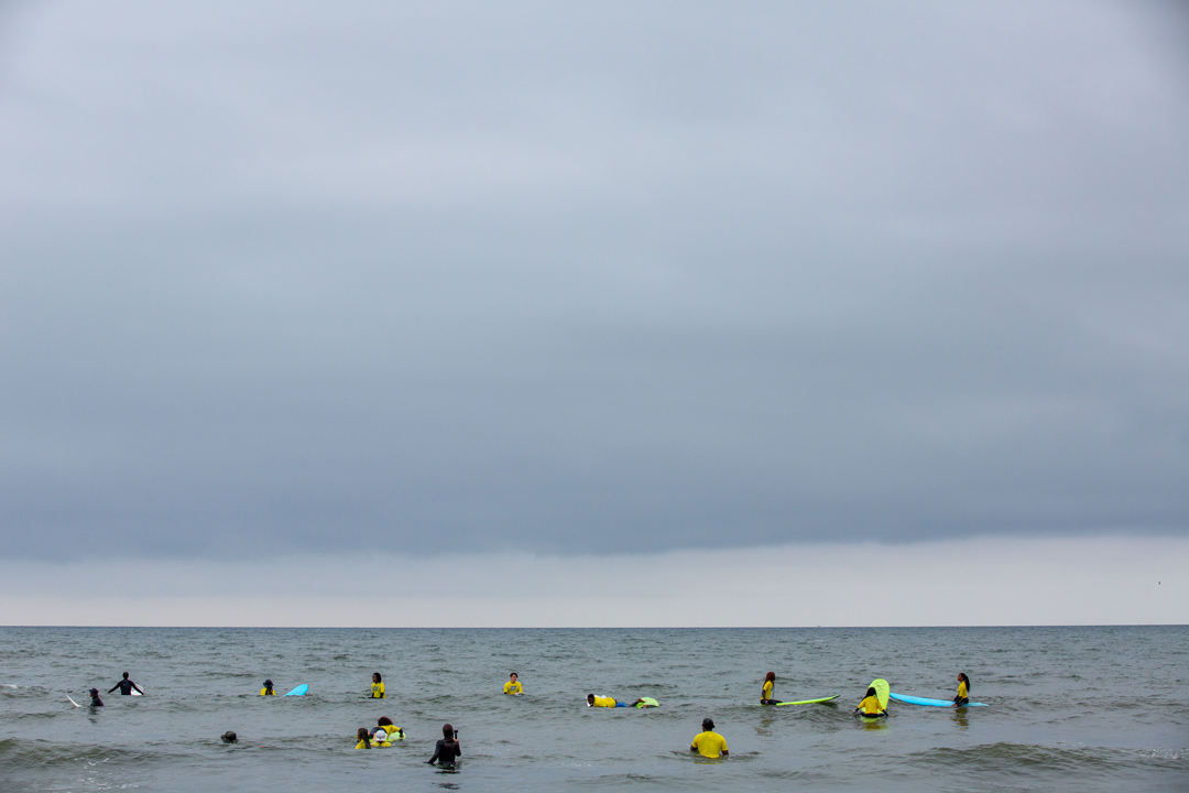 a big group of people out on the water in the ocean, waiting for their perfect wave.