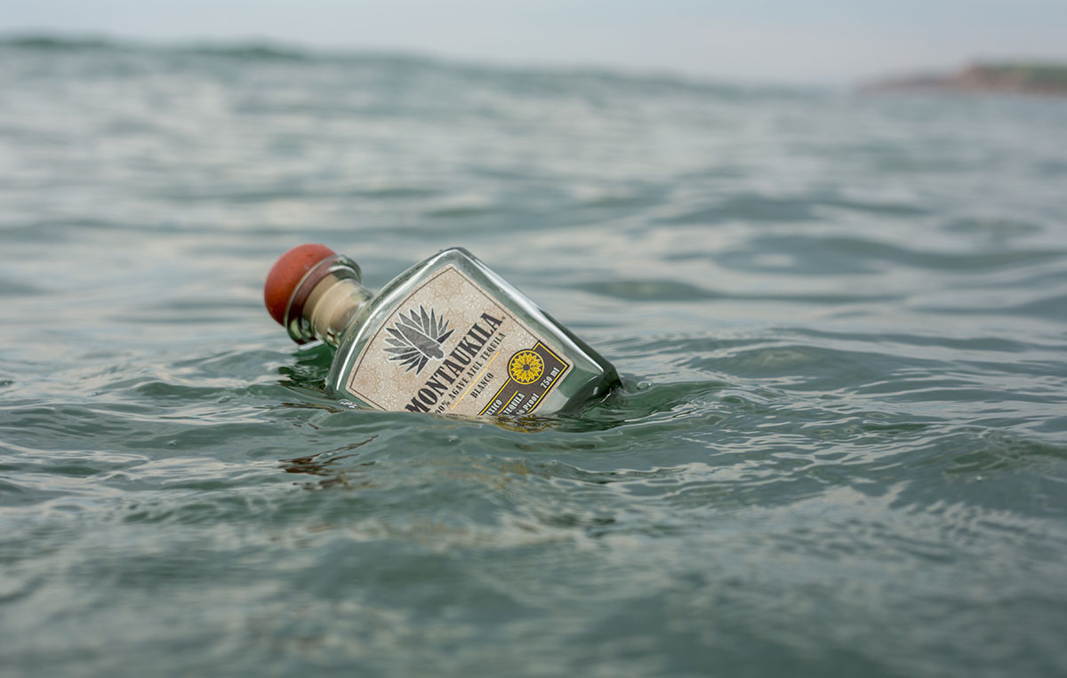 bottle of Montaukila half submerged in water