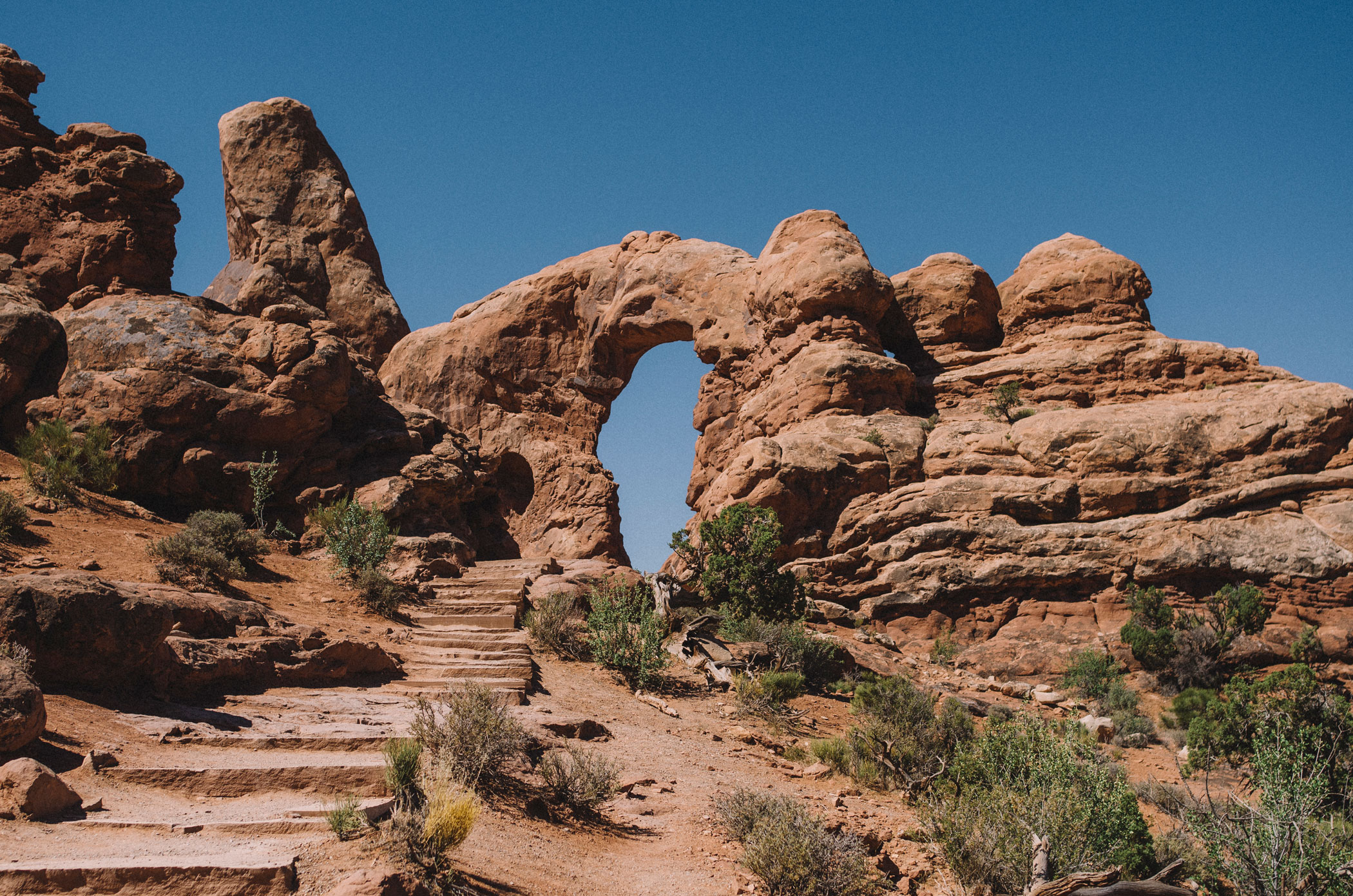 Arches National Park with blue sky behind the rocky landscape.