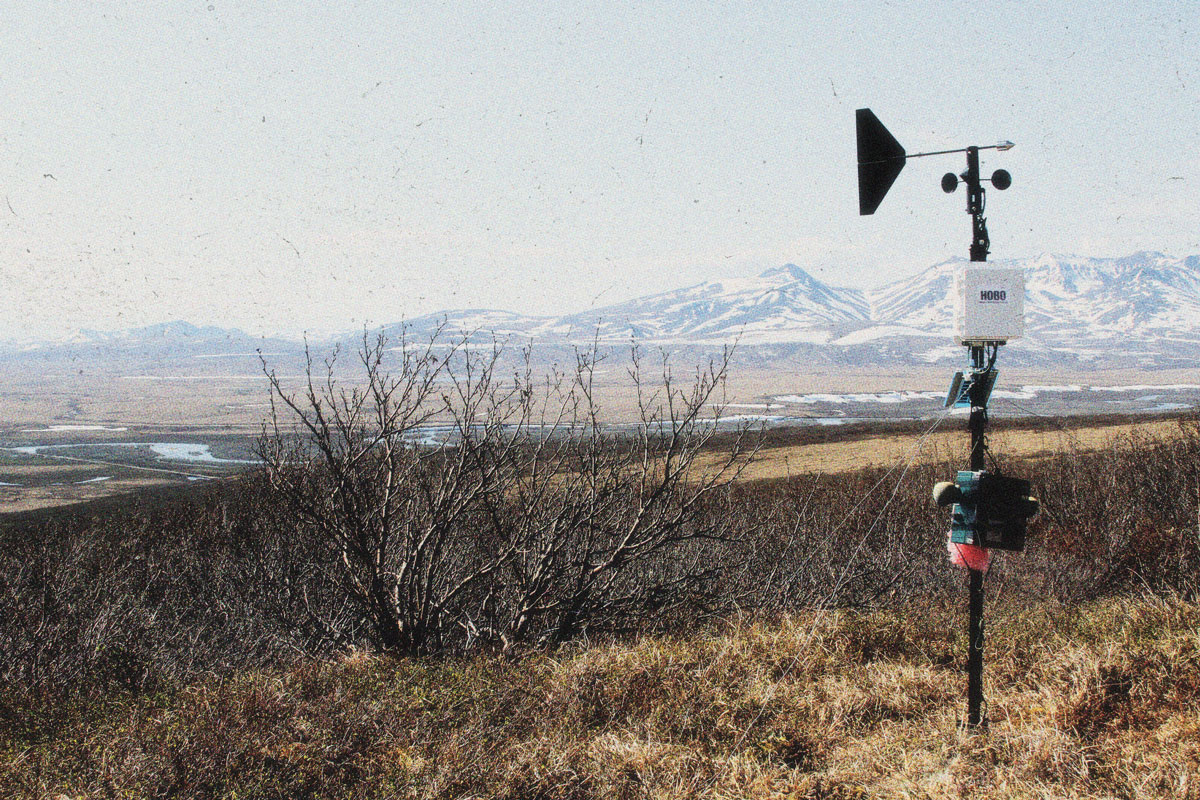 Photo of sound equipment in a national park.  Snow-capped mountains are in the background behind a scene of open plains and rivers. 