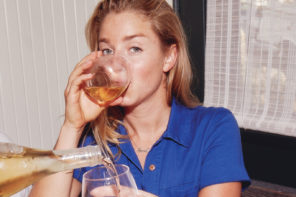 Molly Baz sipping wine in blue.