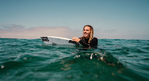 Professional surfer Kyuss King in water with board