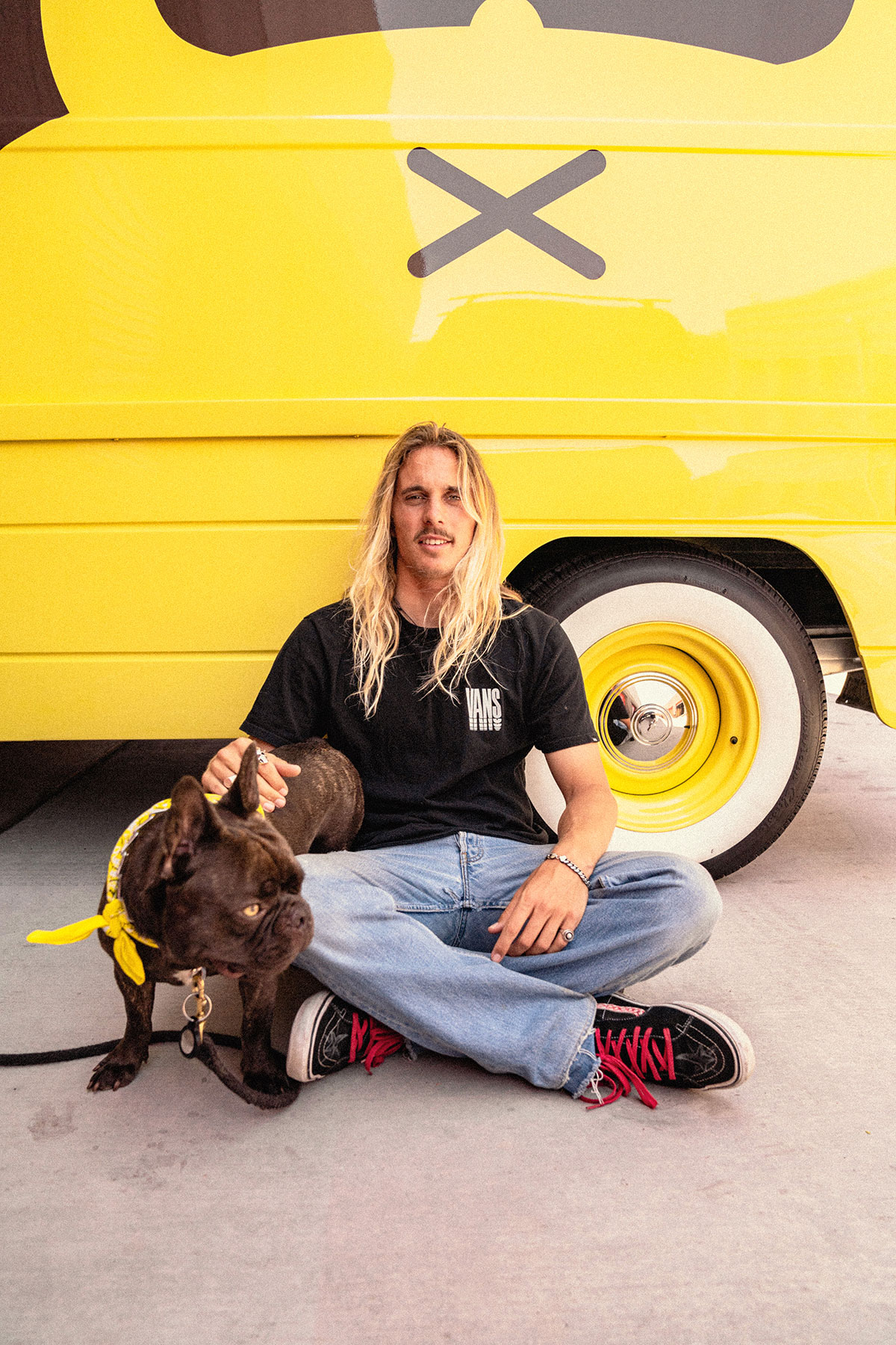 professional surfer Kyuss King sitting on ground with dog