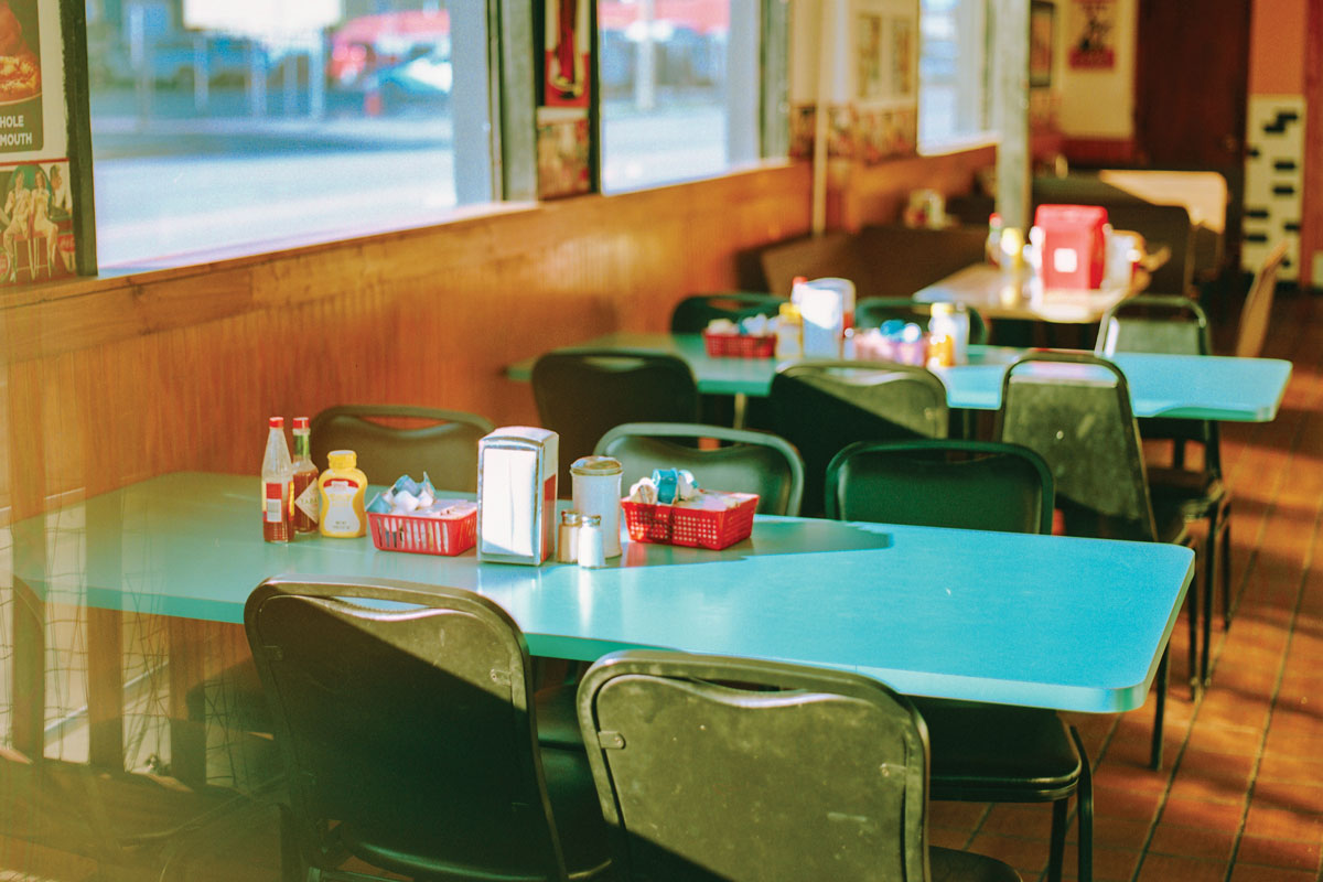 vibrant diner with teal tabletops and ketchup mustard napkin holder on the table