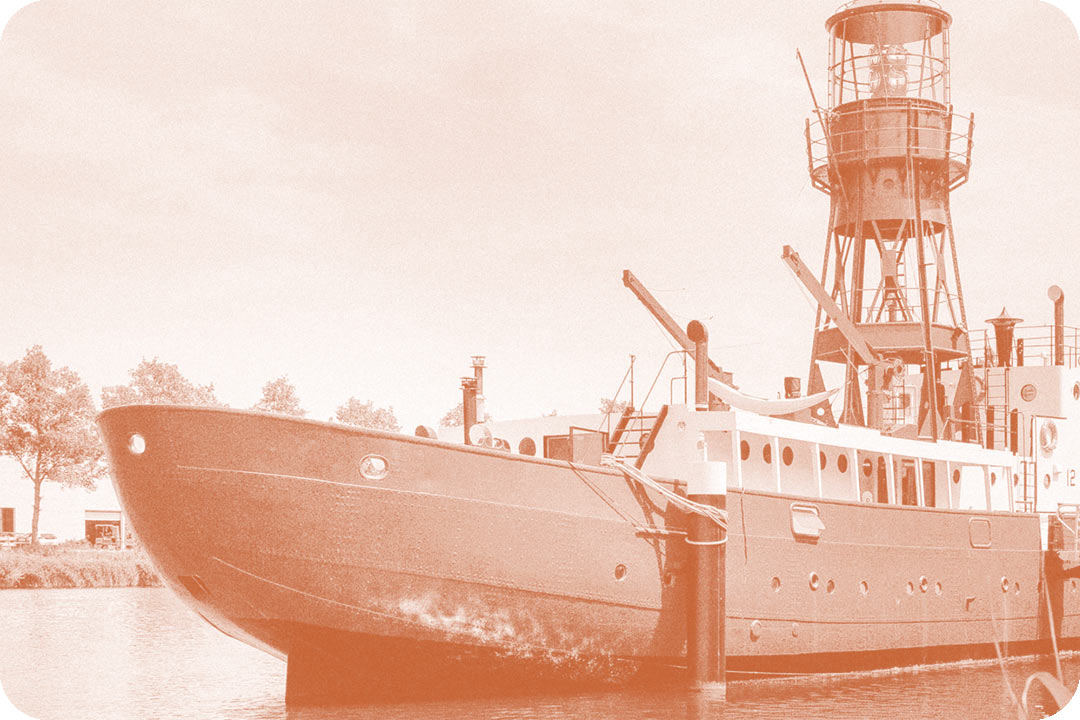 Large 1950's ship tied to posts along the bank of the water. The ship had port hols lining the sides and a tall metal tower in the middle of it with a light at the top. The photo has a pink colored overlay on top of it.