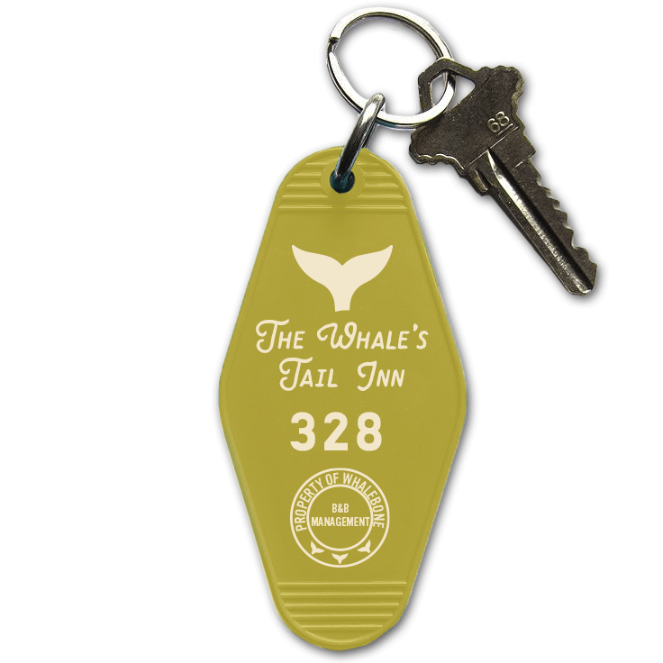 Plastic, green motel room keychain. The keychain has a whale's tail illustration at the top, the words "The Whale's Tail Inn" on it and the room number 328. There is also a circle stamp at the bottom that says "property of Whalebone B&B management".