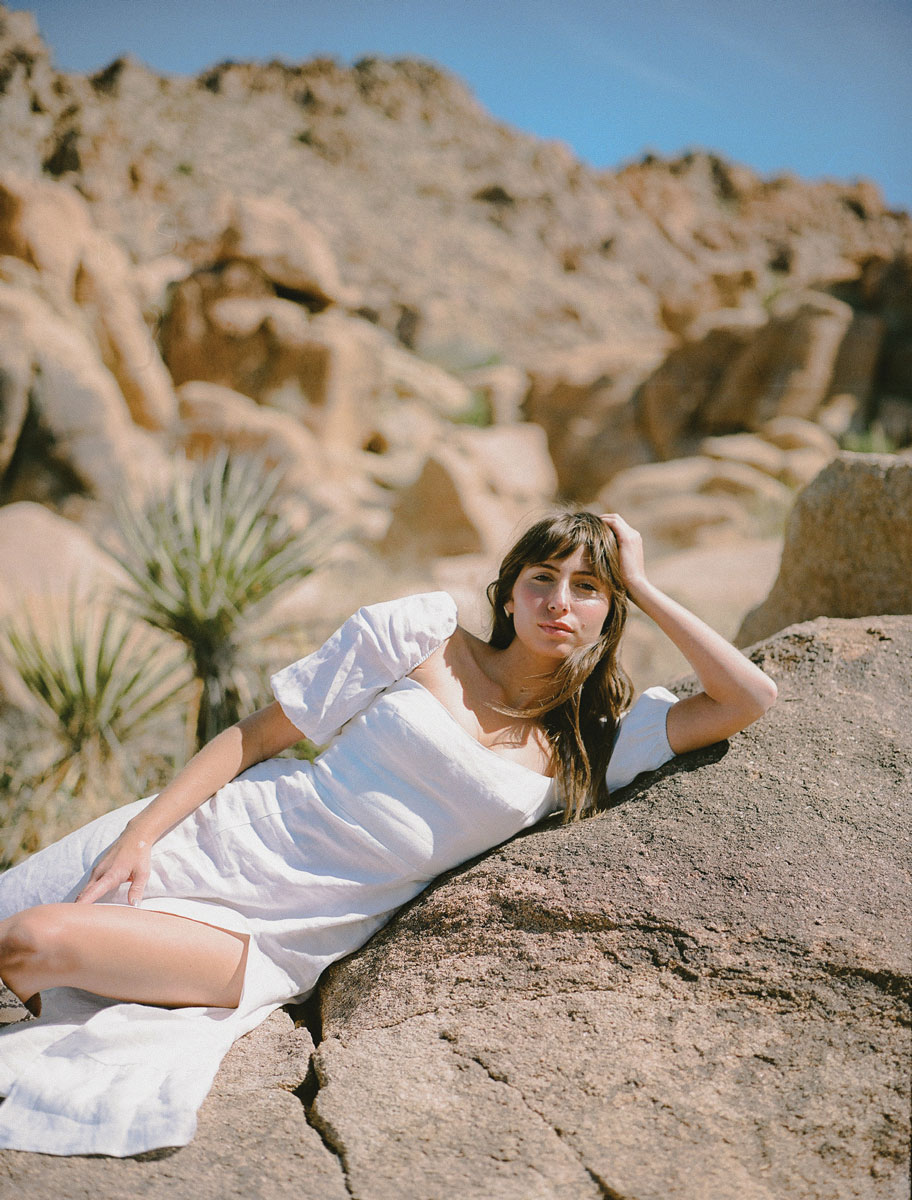 Lily Meola posing on rocks in a desert.