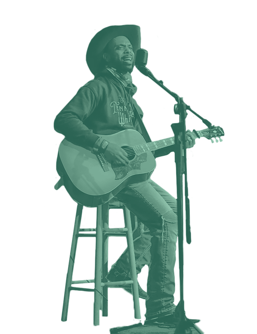 A cut out photo of a man siting on a bar stool and holding a guitar, singing into a microphone. He's wearing jeans, boots, a hoodie, and cowboy hat. The photo has a green colored overlay on top of it.