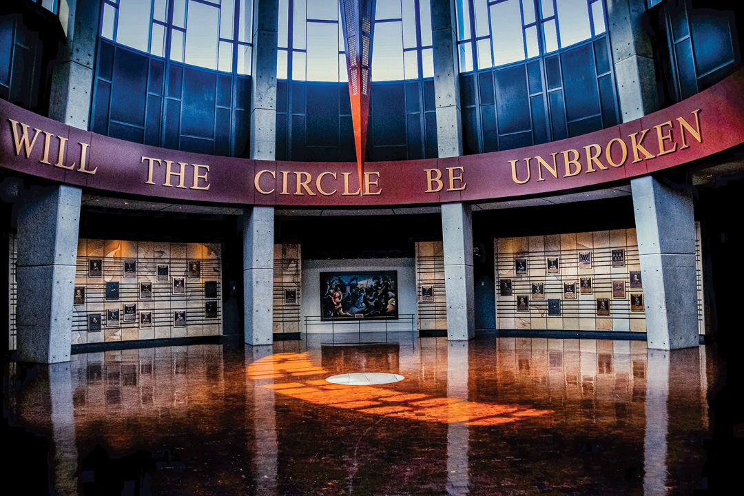 Circular room in the Nashville country music gallery. The top of the room has tall windows, underneath the windows are the words " Will the circle be broken" is gold letters on a red band around the room. Underneath the sign are plaques lining the walls.