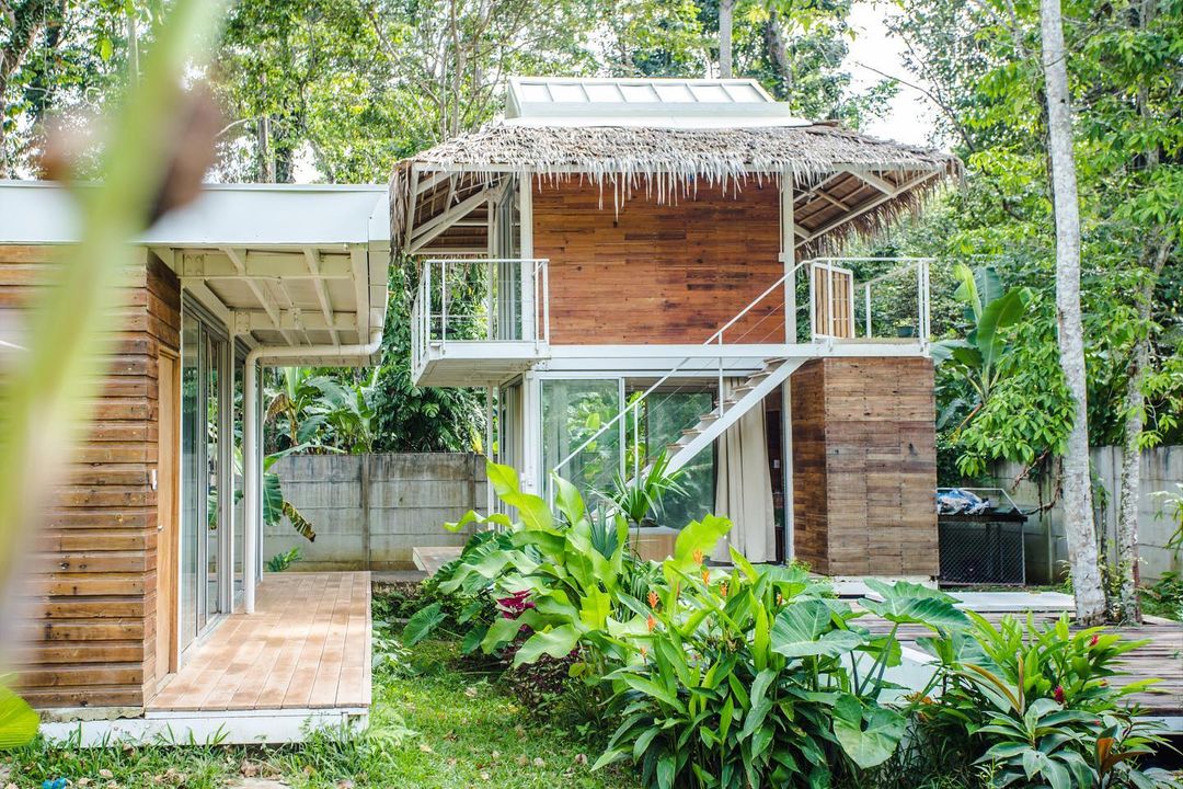 bright outdoor shot of a tropical wooden house by architect Gussa