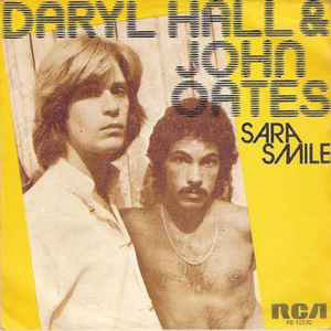 Yellow background album cover of Daryl Hall and John Oates for Sara Smile. Two musicians on the cover in a sepia toned photograph. 