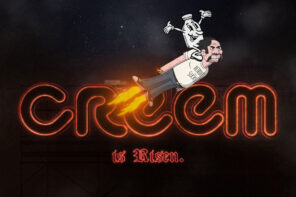Photo of the CREEM magazine logo and the words "IS RISEN" below it in neon red lighting against a dark black background. A cartoon version of Lester Bangs with dark hair and a mustache is flying across the photo with flames coming from his feet and the CREEM mascot riding on his back. He is wearing his classic "DETROIT SUCKS" t-shirt.