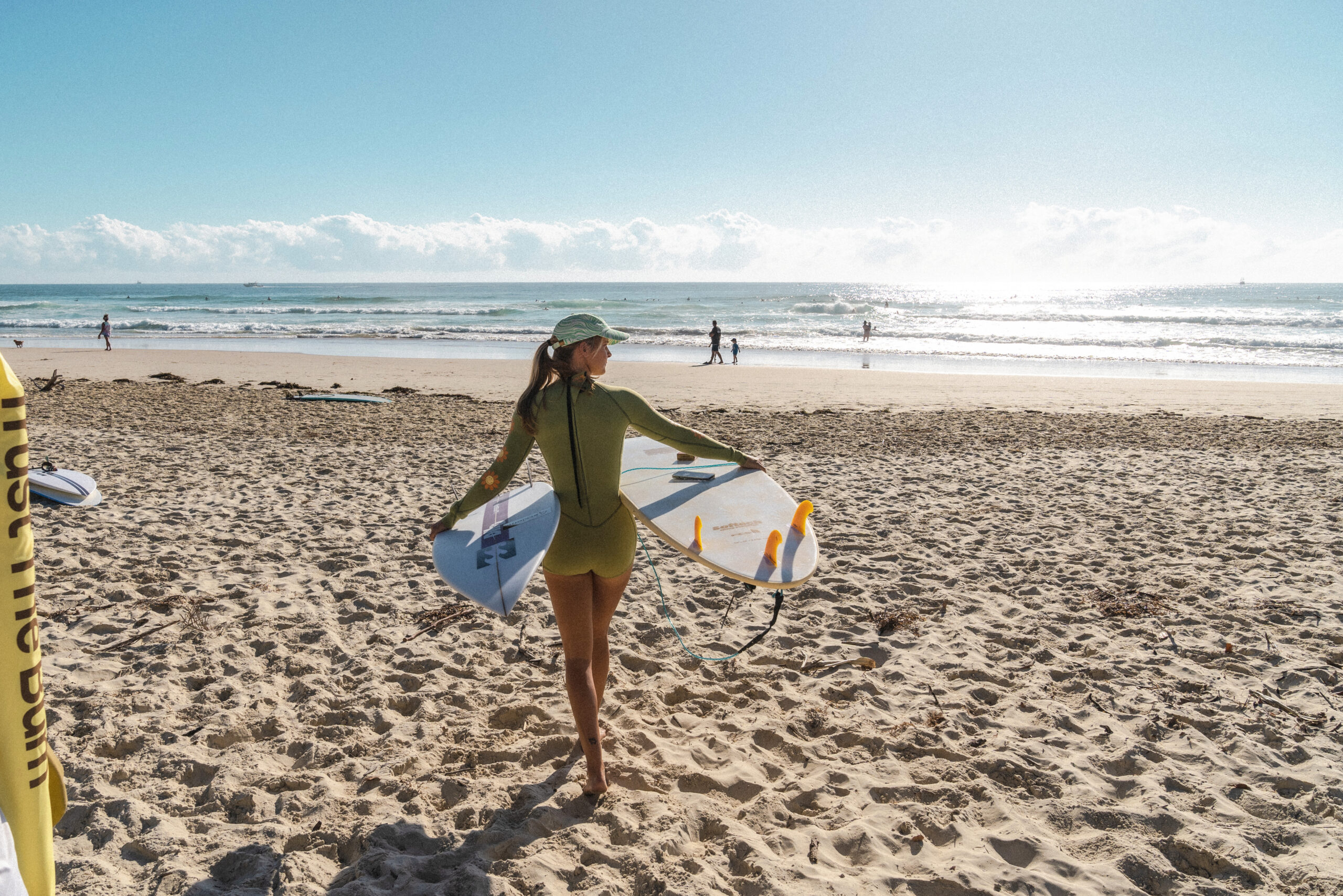 Woman walking toward the water with a surfboard in hand