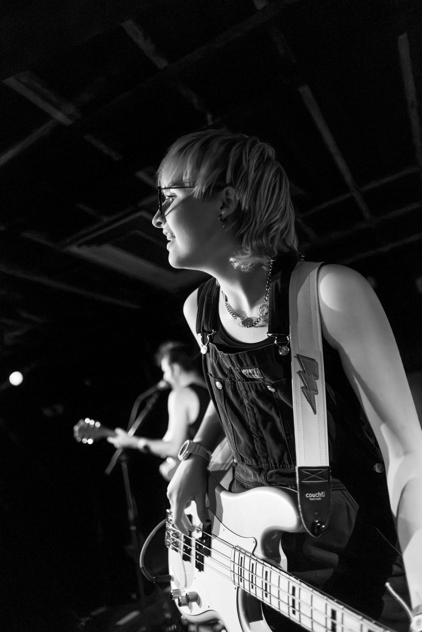 A black and white picture of a bassist playing while looking out into the crowd